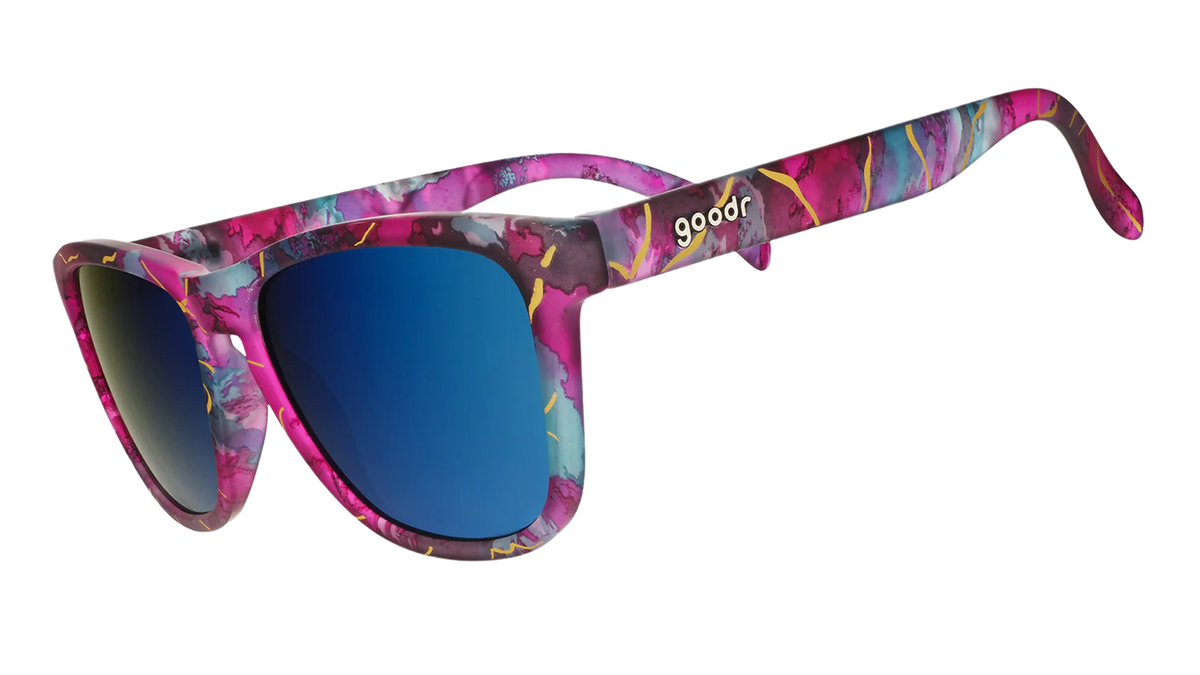 Multi-coloured sunglasses with a prominent gold line pattern. Pinks, purples, and blues on these square-shaped frames.
