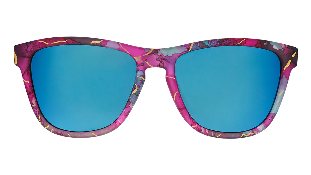 Multi-coloured sunglasses with a prominent gold line pattern. Pinks, purples, and blues on these square-shaped frames.