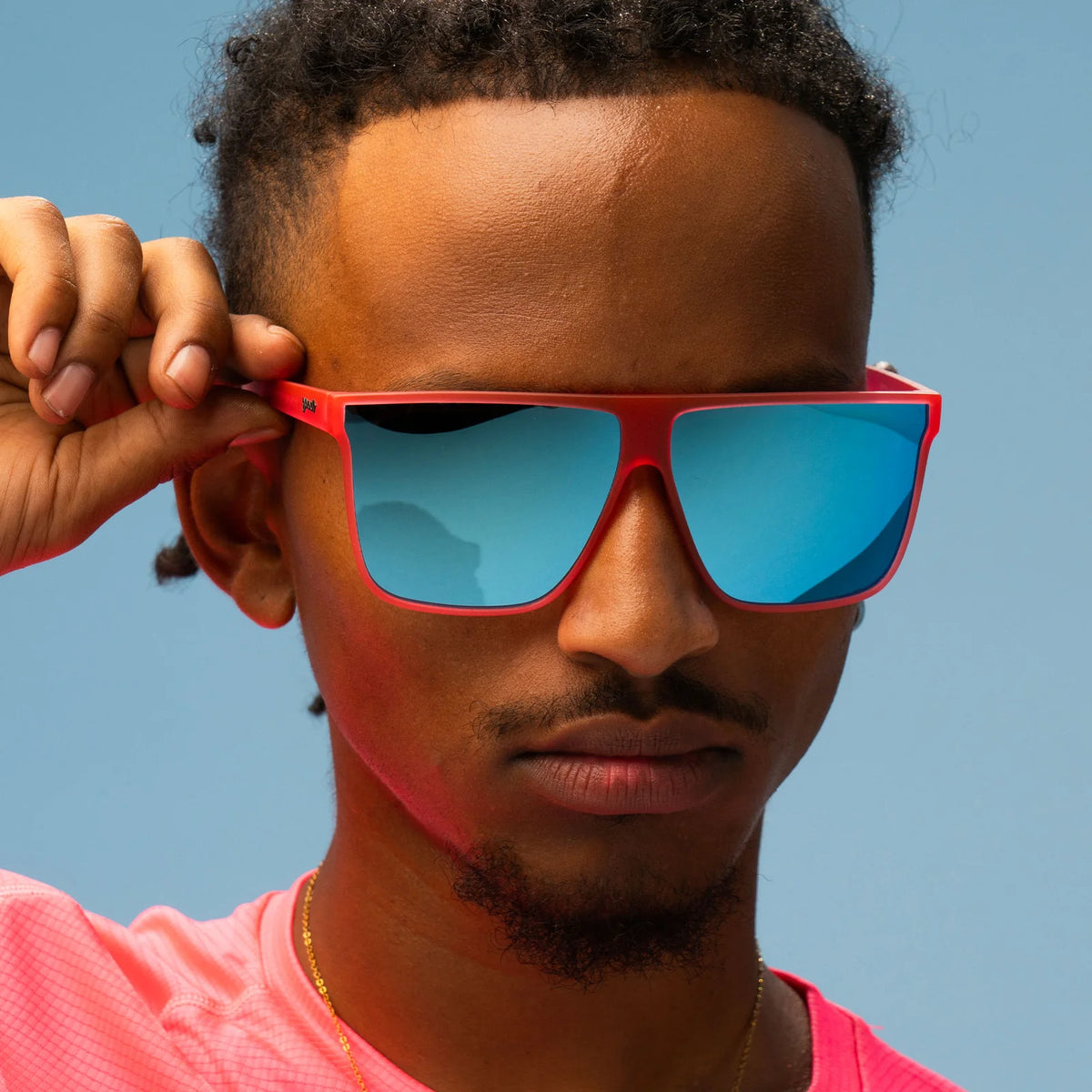 Style and fit showcase of hot pink sunglasses with mirrored reflective lenses in teal. Flat-top frames with a wider fit. No slip, no bounce, all polarised.