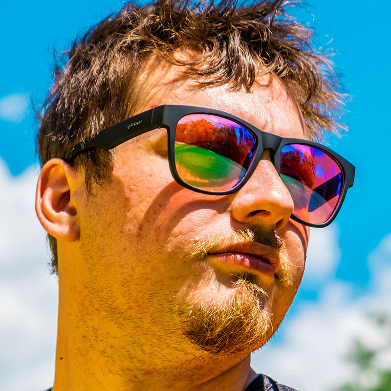 Product close up of large, square-framed black sunglasses with rose-tinted lenses.
